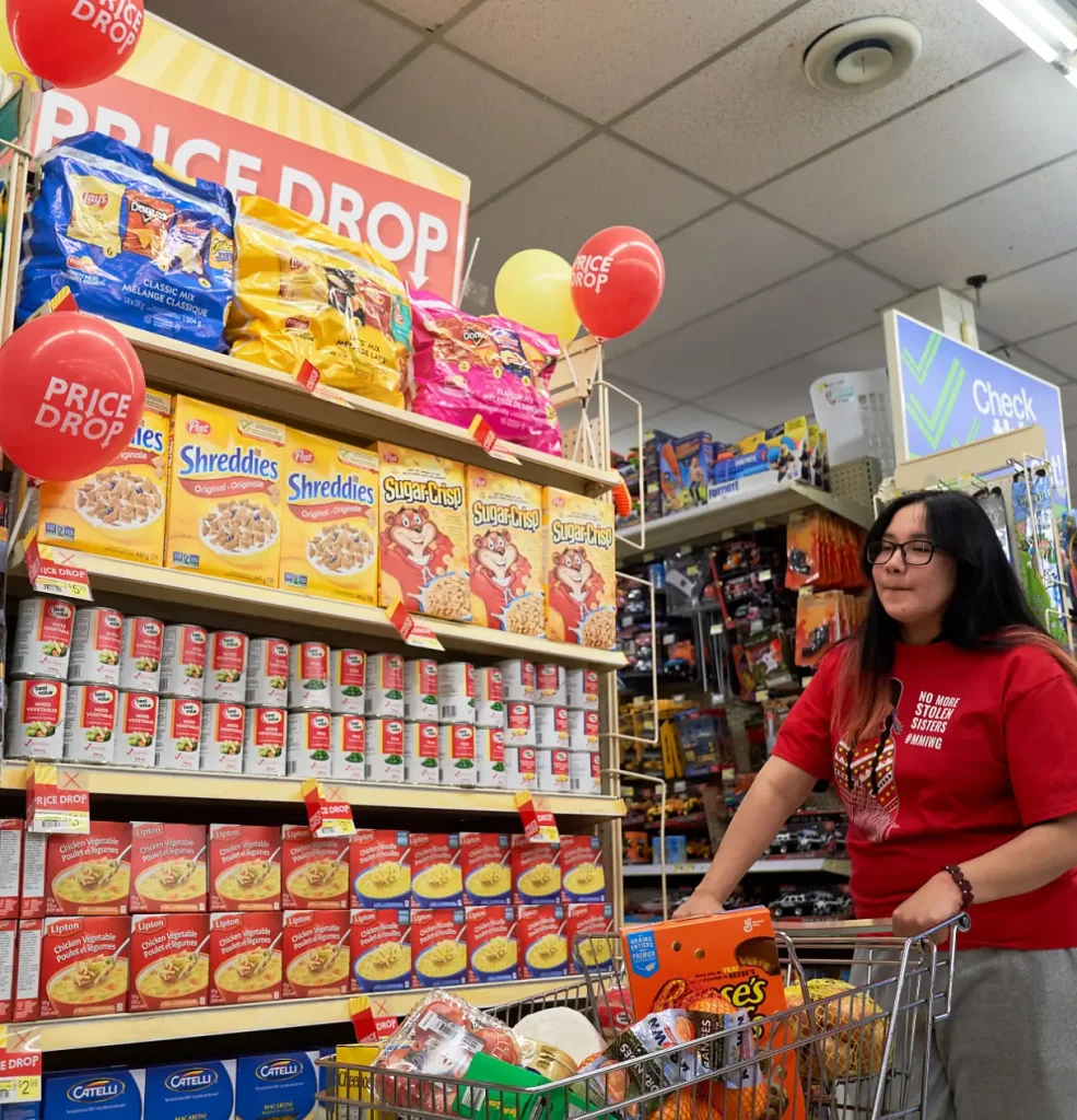 Girl in red t-shirt walking by a Price Drop end
