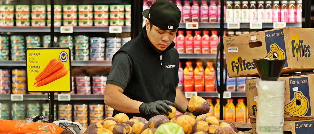 Northern employee wearing gloves and checking the produce